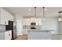Modern kitchen boasts white cabinets, stainless steel appliances, granite countertops, and pendant lighting at 4327 Silver Creek St, Kissimmee, FL 34744