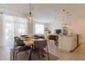 Bright dining area with seating for six, modern pendant lighting, and sliding glass doors to outdoor patio at 4835 Memories Ln, Kissimmee, FL 34746