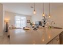 Bright and open kitchen with modern countertop, pendant lighting, and seamless integration with living space at 4835 Memories Ln, Kissimmee, FL 34746