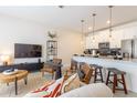Cozy living room featuring stylish furnishings, a large TV, and an open-concept design with the kitchen at 4835 Memories Ln, Kissimmee, FL 34746