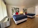 Bright bedroom featuring two beds with blue covers, bamboo art, and laminate floors at 5245 W Irlo Bronson Memorial Hwy # 210, Kissimmee, FL 34746