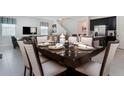 Elegant dining area with a modern table setting, seamlessly connected to the living room and kitchen at 9038 Pelican Cove Trce, Kissimmee, FL 34747