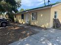 Side view of a yellow home featuring a modest yard with a concrete walkway leading to the front door at 98 Orange Park Blvd, Lake Wales, FL 33898