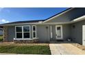 Charming home featuring a gray exterior, large window, and inviting walkway at 804 Wildwood Cir, Port Orange, FL 32127