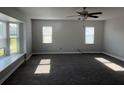 Spacious living room featuring gray carpet, natural light, and a ceiling fan at 804 Wildwood Cir, Port Orange, FL 32127