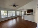 Bright living room with wood floors, ceiling fan, and view to kitchen with counter seating at 1027 S Hiawassee Rd # 2323, Orlando, FL 32835
