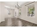 Bright dining room with wood-style tile flooring and modern chandelier at 11843 Fiction Ave, Orlando, FL 32832