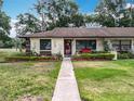 Charming home with a landscaped yard, flower beds, and beautiful walkway at 12539 Orangewood Ct, Tavares, FL 32778