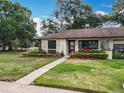 Charming home with a landscaped yard, flower beds, and beautiful walkway at 12539 Orangewood Ct, Tavares, FL 32778
