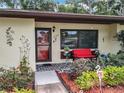 Charming home with a landscaped yard, flower beds, and a bright red bench at 12539 Orangewood Ct, Tavares, FL 32778
