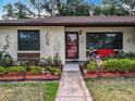Charming home with a landscaped yard, flower beds, and decorative touches at 12539 Orangewood Ct, Tavares, FL 32778