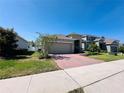 Lovely single-Gathering home with a two-car garage, brick driveway, and lush green lawn at 1321 Yorkdale Rd, Davenport, FL 33837
