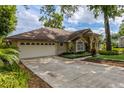 Spacious driveway leading to a home with a well-kept lawn and mature trees at 154 Academy Oaks Pl, Altamonte Springs, FL 32714