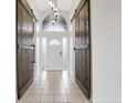 Inviting foyer with tile flooring, barn doors, decorative lighting, and frosted glass front door at 154 Academy Oaks Pl, Altamonte Springs, FL 32714