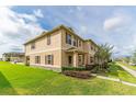 Charming townhome exterior with lush green lawn and inviting curb appeal at 1818 Katz Crossing Dr, Kissimmee, FL 34744