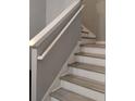 White wood staircase with light wood treads and handrail with neutral paint at 247 Verona Ave, Davenport, FL 33897