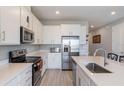 Bright kitchen with stainless steel appliances, white cabinets, an island, and wood-look flooring at 2821 Cathy Blvd, Winter Haven, FL 33880