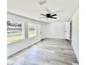 Bright bedroom featuring new paint, vinyl floors, ceiling fan, and natural light from two windows at 2831 Magnolia Ave, Sanford, FL 32773