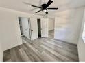 Bedroom showcasing vinyl floors, fresh paint, closet, and connecting doors to other rooms at 2831 Magnolia Ave, Sanford, FL 32773