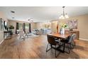 Open-concept living and dining area with wood flooring, stylish furniture, and a view into the kitchen at 4091 Lippman Rd, St Cloud, FL 34772