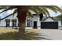 Charming single-Gathering home featuring a clean white exterior and dark accents, along with an attached two-car garage at 414 Otter Creek Dr, Kissimmee, FL 34743