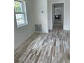 Bright living room featuring charming plank flooring, white walls and ample natural light from the window at 5562 Old Tampa Hwy, Davenport, FL 33896