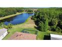 Aerial view of the backyard with an enclosed pool and a lush tree-lined property at 650 Portofino Drive, Poinciana, FL 34759