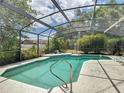 Inviting in-ground pool surrounded by a screened enclosure and lush landscaping at 724 Knob Hill Cir, Kissimmee, FL 34744