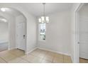 Bright dining area featuring tile floors, chandelier, and a large window at 724 Lake Cummings Blvd, Lake Alfred, FL 33850