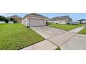 Single-story home featuring an attached two-car garage and large driveway at 724 Lake Cummings Blvd, Lake Alfred, FL 33850