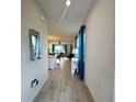 Inviting hallway with wood-look tile flooring leading to an open-concept living space at 755 Driving Range Ct, Reunion, FL 34747
