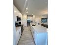 Modern kitchen featuring white cabinetry, quartz countertops, and stainless steel appliances at 755 Driving Range Ct, Reunion, FL 34747