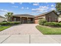 Charming home featuring a brick driveway, covered porch and manicured bushes at 759 Glendora Rd, Poinciana, FL 34759