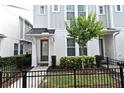 Charming townhome featuring gray siding, a cozy front porch, and a black wrought iron fence at 932 Wild Date Ln, Lake Mary, FL 32746