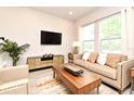 Bright living room featuring a comfortable sofa, modern furnishings, and natural light from large windows at 932 Wild Date Ln, Lake Mary, FL 32746