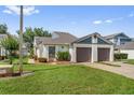 Single-story home features a well-manicured lawn and an attached two-car garage with mature flowering landscaping at 98 Lakepointe Cir, Kissimmee, FL 34743