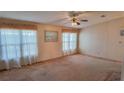 Spacious living room featuring neutral carpet, ceiling fan, and bright window light at 509 Tivoli Park Dr, Davenport, FL 33897