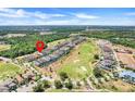 Aerial view of homes on a golf course with lush green landscape and trees at 1021 Castle Pines Ct, Reunion, FL 34747