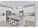 Modern kitchen features a large center island, white cabinets, stainless steel appliances at 1030 Wisteria Way, Dundee, FL 33838