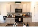 Well-organized kitchen with modern appliances, stylish backsplash, and ample counter space at 11273 Amber Ridge Dr, Zellwood, FL 32798