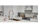 Bright kitchen showcases white cabinetry, stainless steel appliances, and an elegant backsplash at 15929 Moonlight Bay St, Winter Garden, FL 34787