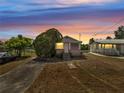 Charming single-story home with a mature tree, pictured at sunset at 1626 Salmon St, St Cloud, FL 34771