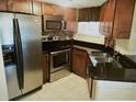 Well-equipped kitchen with stainless steel appliances, dark countertops, and tiled flooring for a modern feel at 1948 Lake Atriums Cir # 115, Orlando, FL 32839