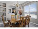 Dining room showcasing wood furniture, a chandelier and ample natural light from a large window at 209 Rosso Dr, Davenport, FL 33837