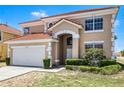 Charming two-story home with a red tile roof, attached garage, and manicured front yard at 209 Rosso Dr, Davenport, FL 33837