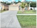 Beautiful home with a well-manicured lawn, mature trees, and a welcoming entrance at 2346 Lily Pad Ln, Kissimmee, FL 34743