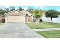 Charming single-story home with a well-maintained front yard and a two-car garage at 2346 Lily Pad Ln, Kissimmee, FL 34743