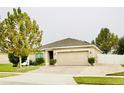 A well-maintained single-story house with brick driveway, neutral paint, and mature landscaping at 247 Whispering Pines Way, Davenport, FL 33837