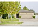 Charming single-story home with a well-manicured lawn and a two-car garage and mature landscaping at 247 Whispering Pines Way, Davenport, FL 33837