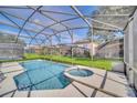 Relax in this beautiful screened-in pool and spa with views of the lush backyard at 2632 Emerald Island Blvd, Kissimmee, FL 34747